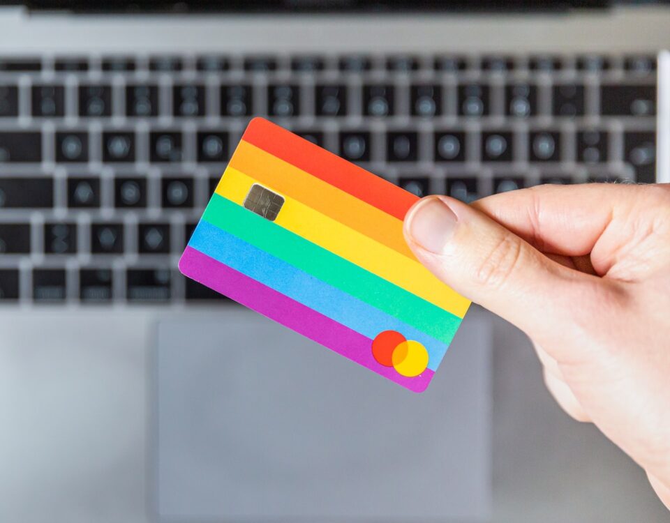 Cartão de crédito com as cores do arco íris na mão de uma pessoa