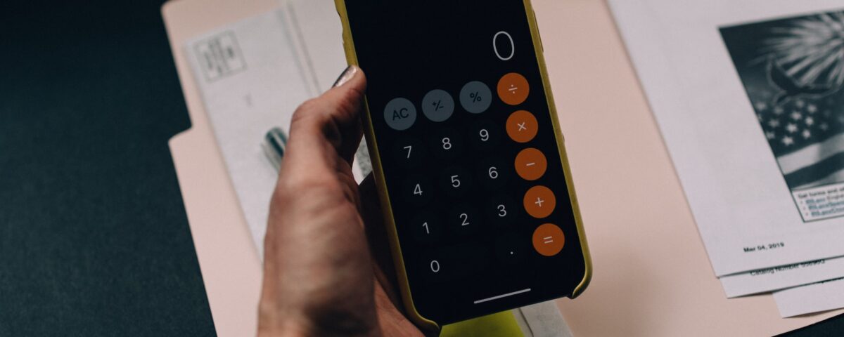 Mão segurando calculadora para controlar gastos